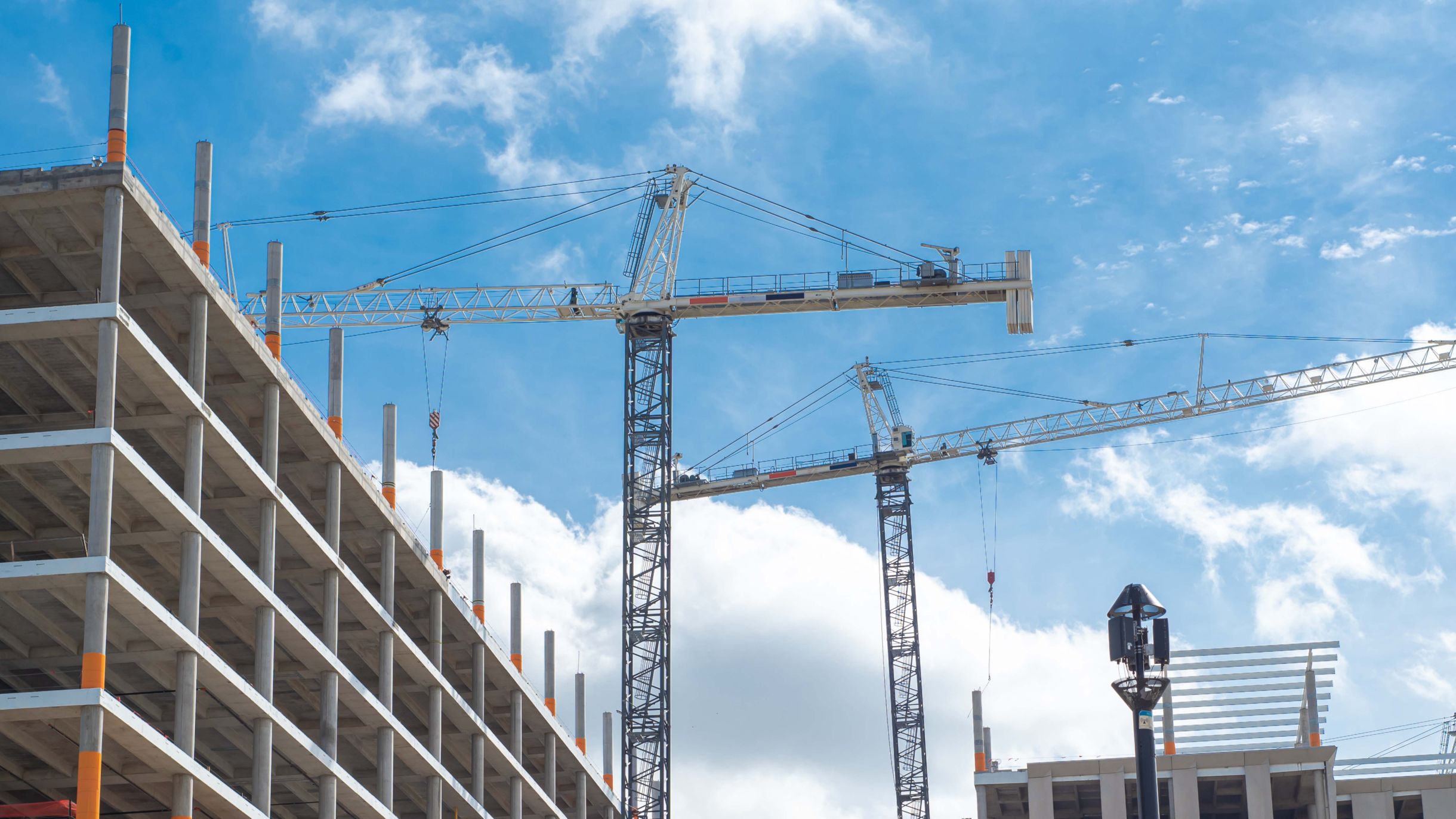 Multi-storey precast concrete structure with tower cranes, showing fast and predictable on-site installation.