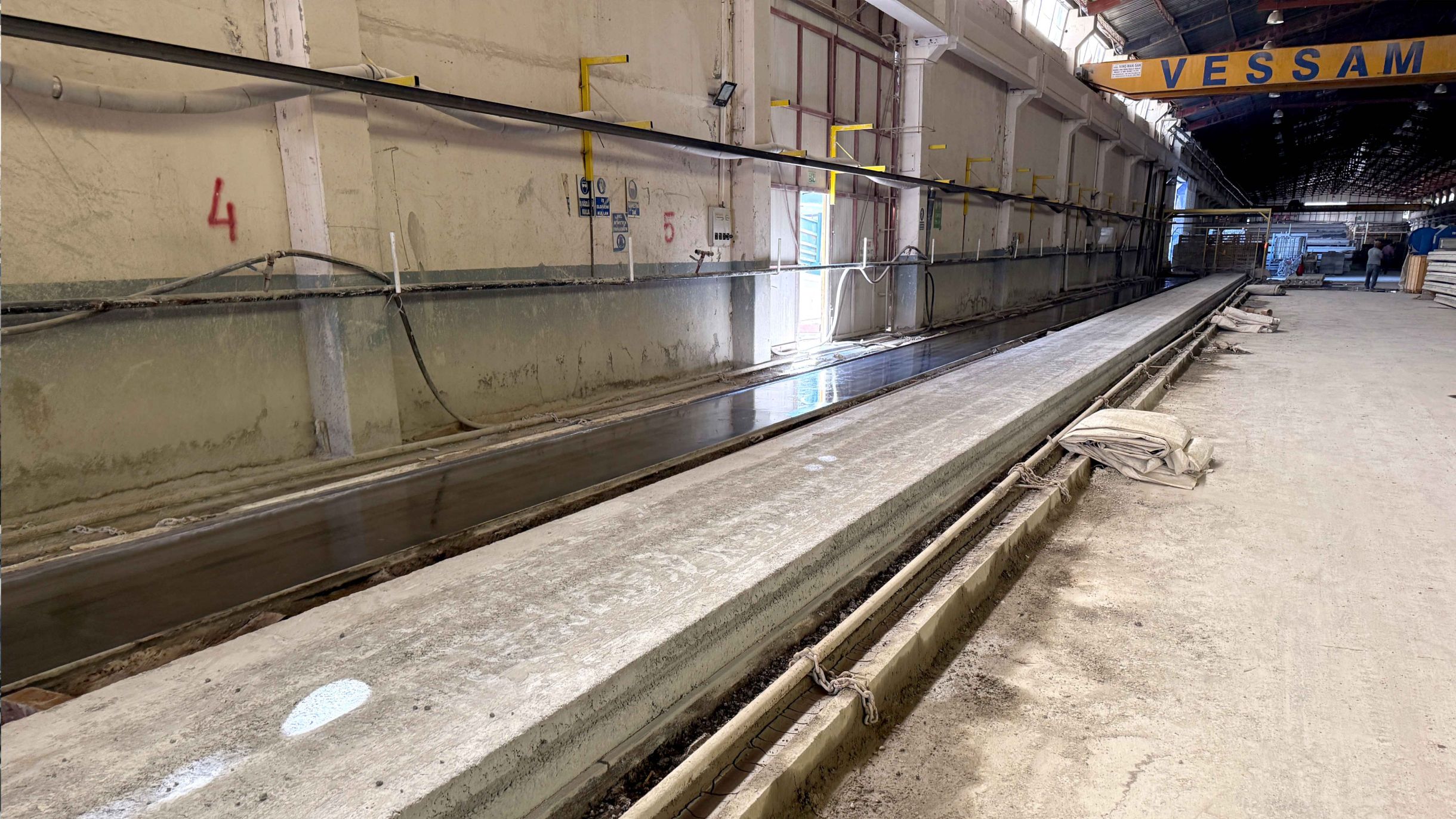 Production bed for hollowcore slab manufacturing at Vessam Prefabrik with prepared production surface.